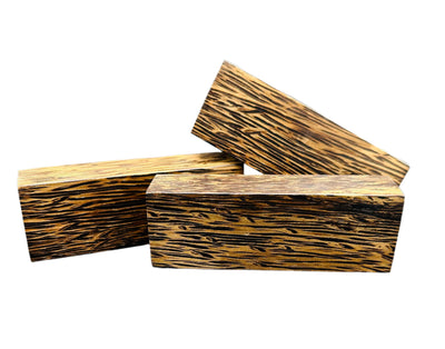 Black Palm is a unique and visually striking knife handle material. It has distinct black fibers interspersed with lighter shades, black palm creates a beautiful contrast and adds an exotic touch to any knifemaking project. Shown is three blocks next to each other. 