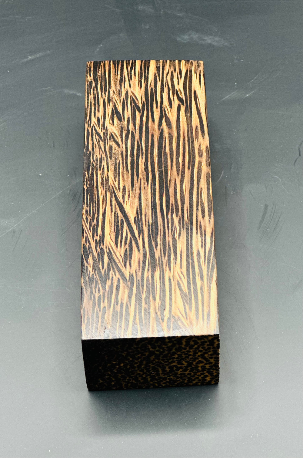 Black Palm is a unique and visually striking knife handle material. It has distinct black fibers interspersed with lighter shades, black palm creates a beautiful contrast and adds an exotic touch to any knifemaking project. Shown is one block with yellow and black streaks. 