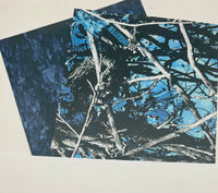 
              Blue camouflage-patterned paper with tree branches.
            