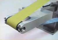 
              Image of the attachment on a knife making grinder with a yellow belt. 
            