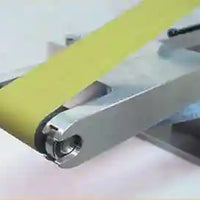 Image of the attachment on a knife making grinder with a yellow belt. 